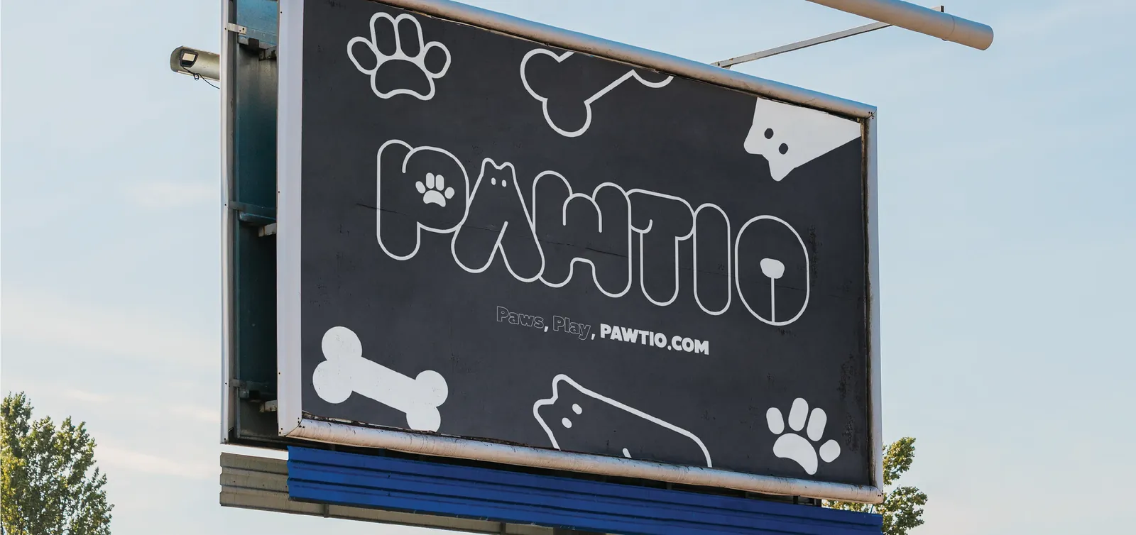 A PAWTIO billboard against a blue sky: the wordmark, “Paws, Play, PAWTIO.COM” and pattern shapes.