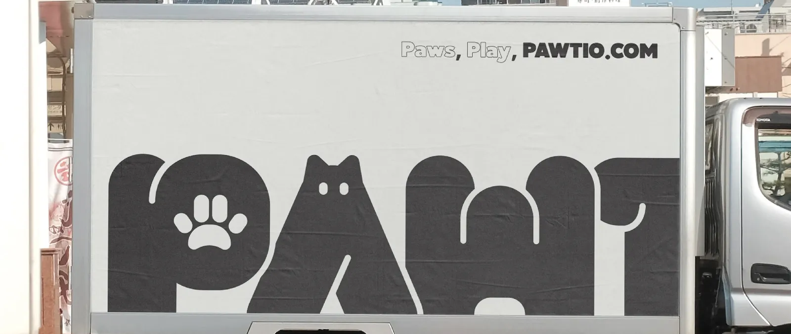 A delivery truck wrapped with an oversized PAWTIO wordmark and the slogan “Paws, Play, PAWTIO.COM”.
