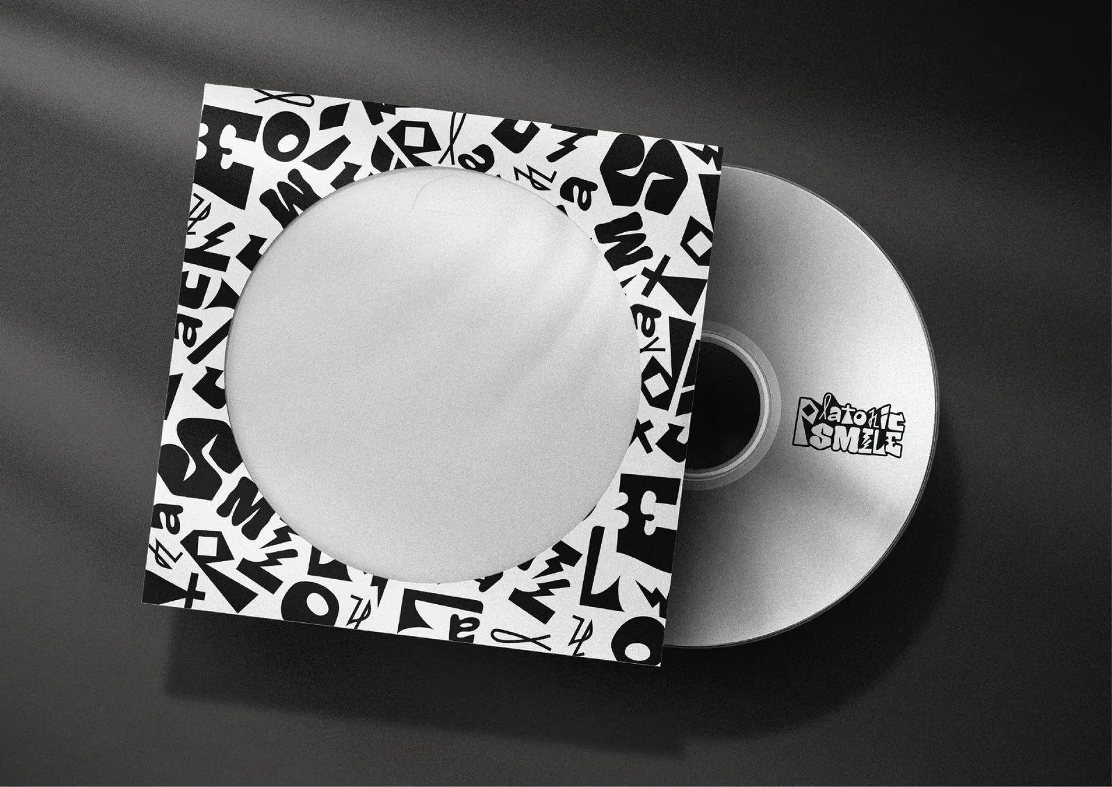 An album sleeve covered in the Platonic Smile letter pattern, with the disc sliding out.
